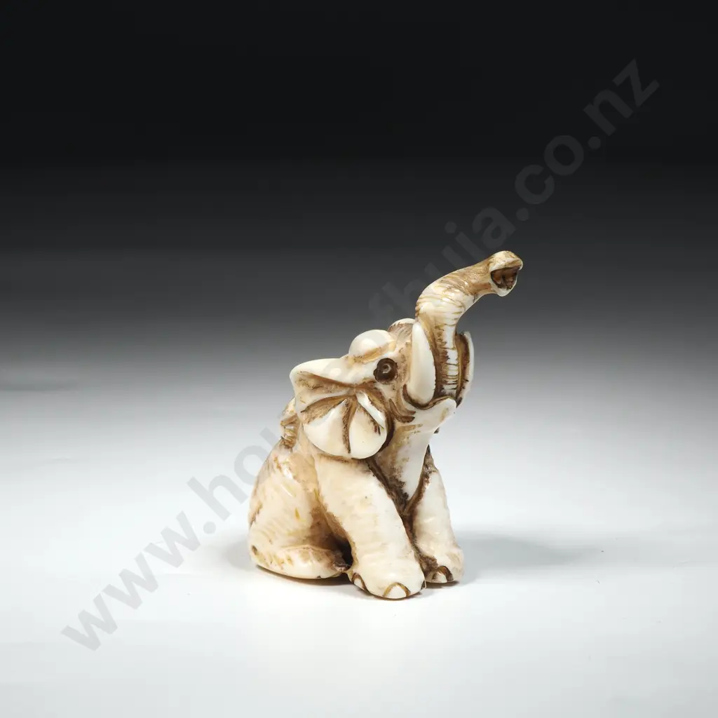 Carved Ivory Netsuke Featuring A Seated Elephant with Uplifted Trunk. Image 1++