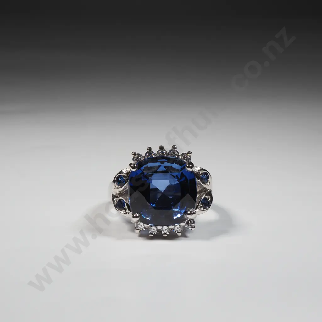 Silver Dress Ring Set With Central Cushion Cut Blue Stone & Smaller Accent Blue & White Stones On The Band & Halo Image 1++