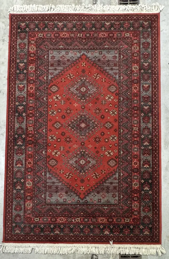 Traditional Red Ground Oriental Rug w a Central Geometric Pattern & Fringed Ends Image 1++