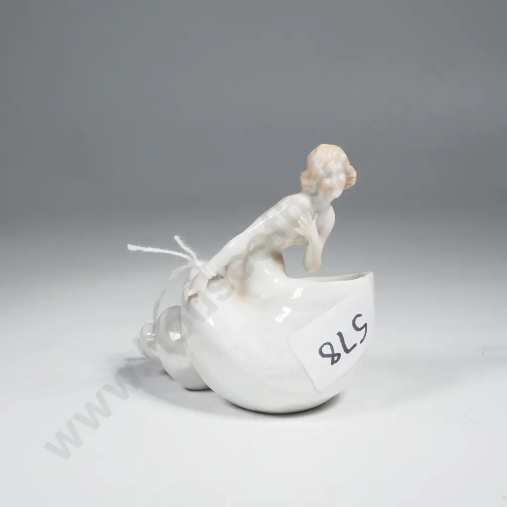 Small  white  Porcelain Figurine Depicting A Nude Female w Blonde Hair & Flesh Toned Accents Sitting in a Shell Image 1++