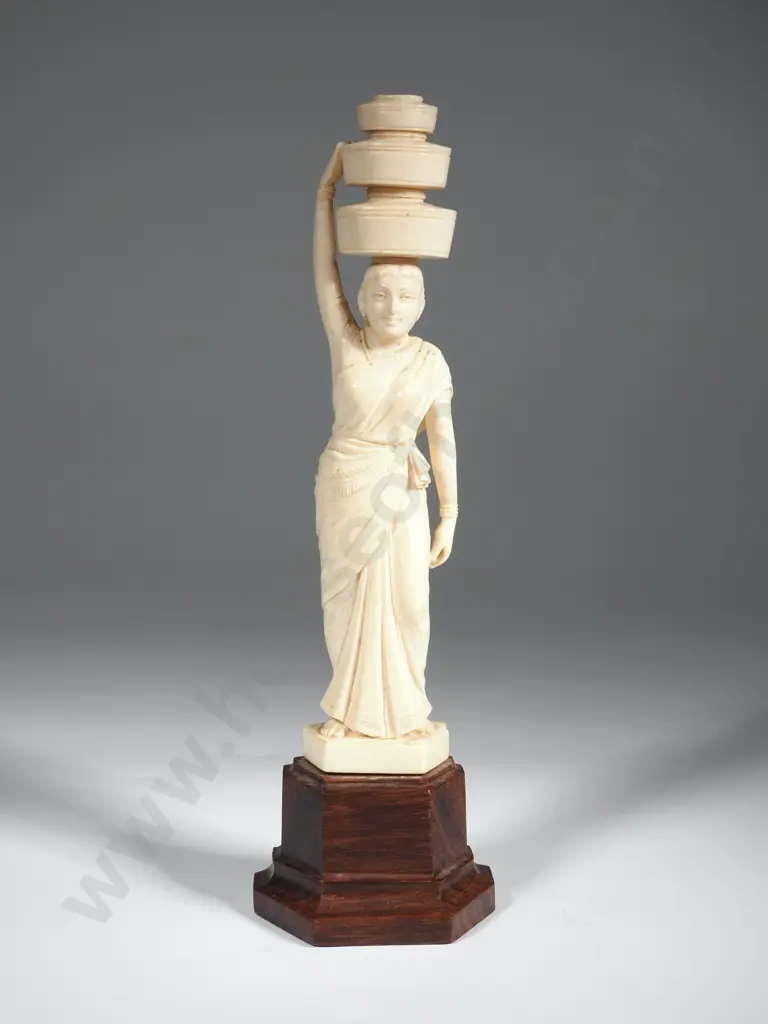 An  Ivory Indian Carving Of A Female Carrying Three Basket Above Her Head And Resting On a Wooden Base Image 1++
